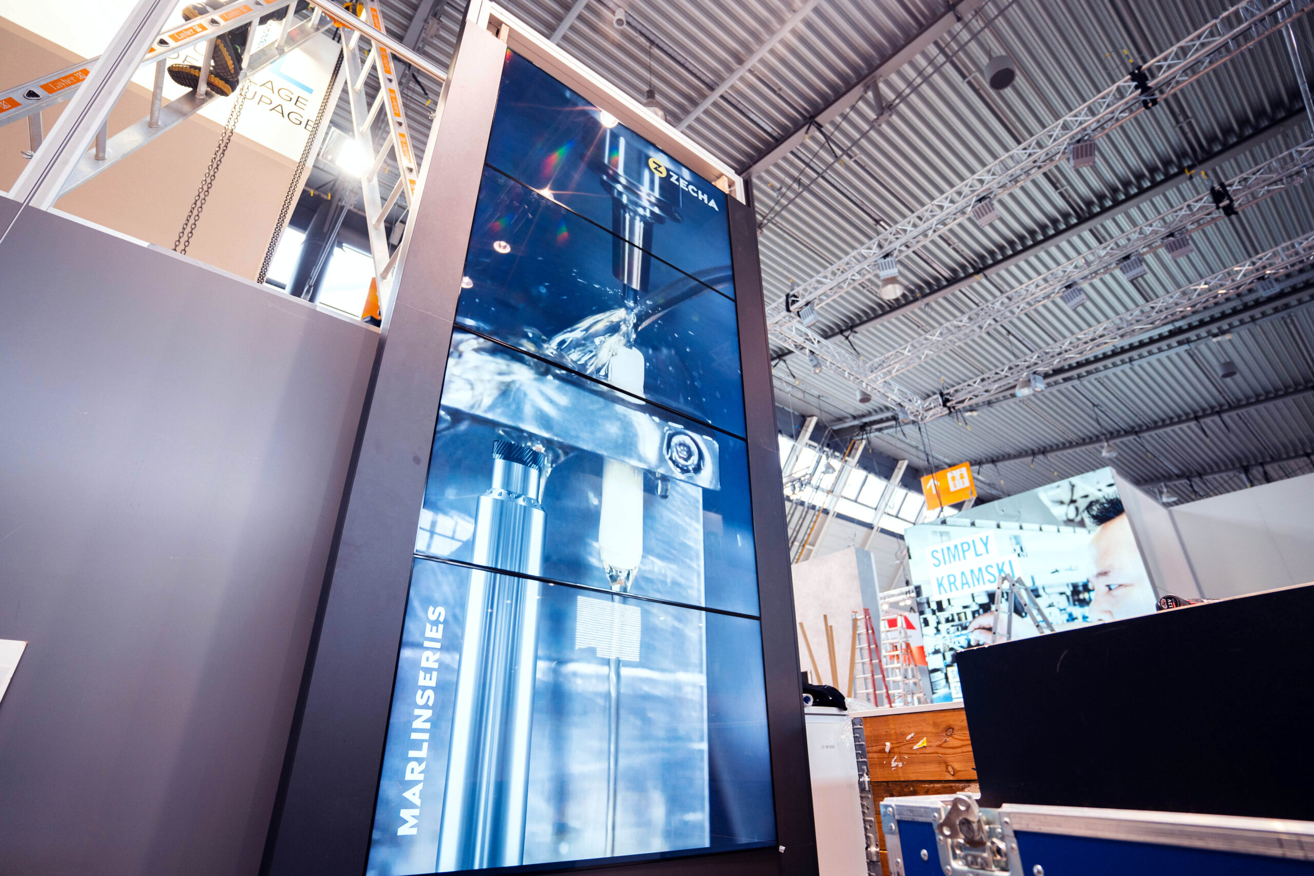 Man sieht 4 übereinanderliegende Monitore für Messestand